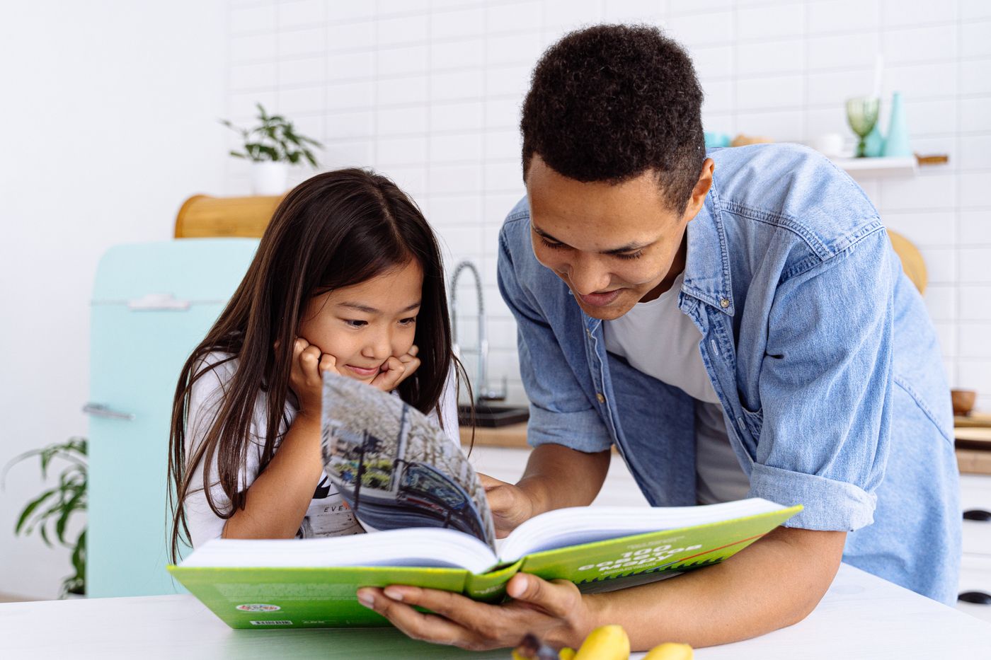 A father and daughter enjoying a book together at home